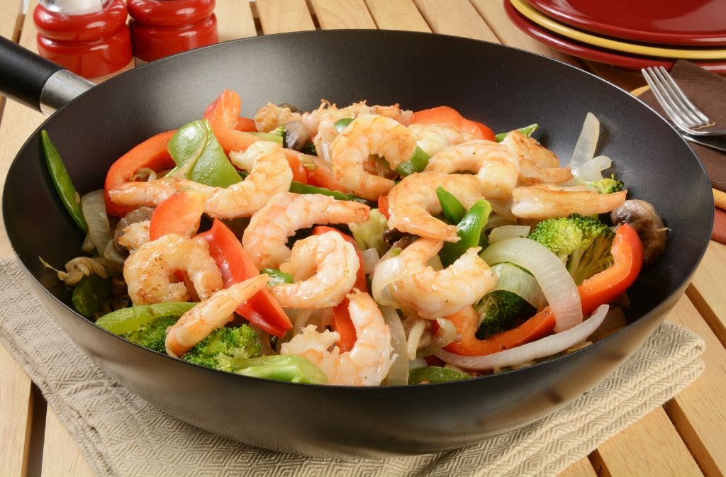 a wok with keto friendly chinese steamed shrimp and vegetables