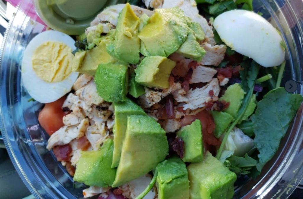 a close up of Panera green goddess salad with avocado hard boiled egg and chicken