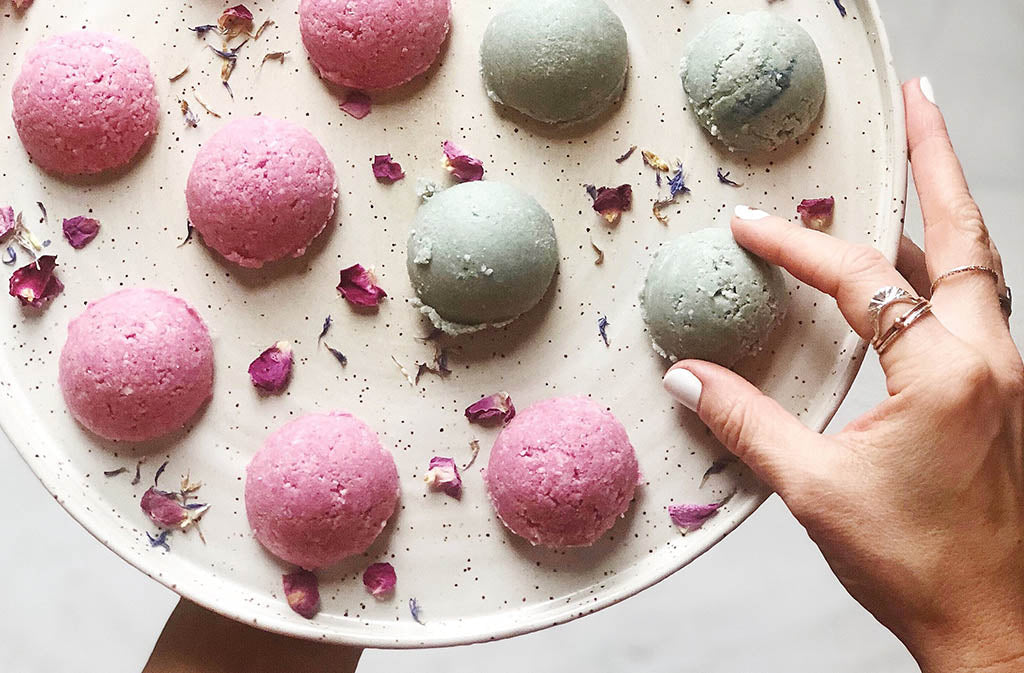 pink and teal energy bites on a round plate