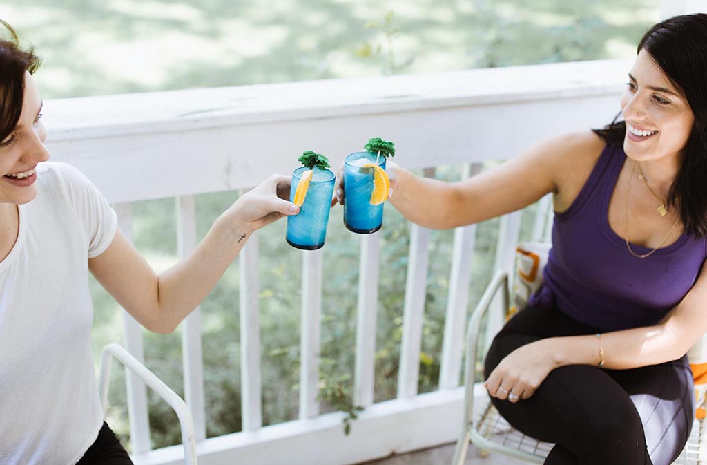 two women holding up their glasses to cheers