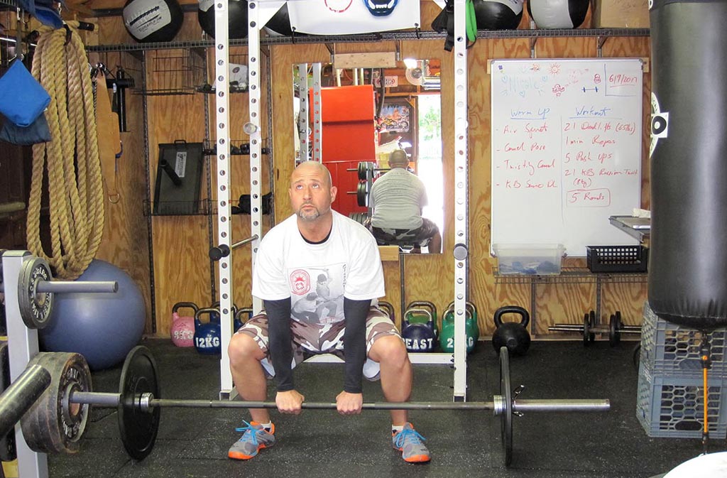 man at starting position of sumo deadlift