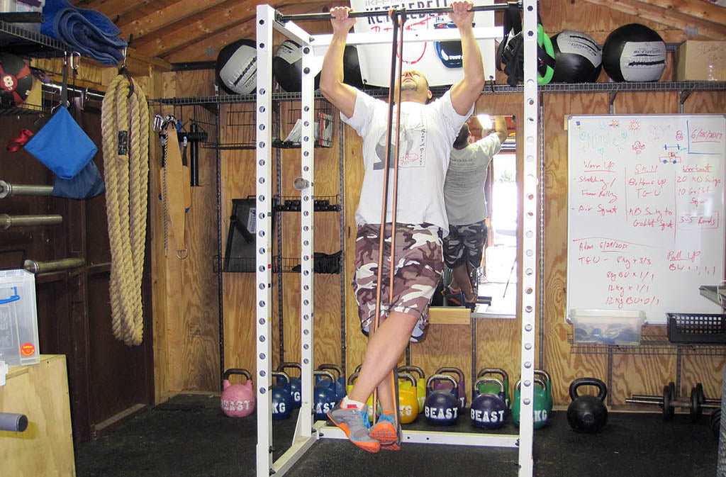 man doing banded pull up