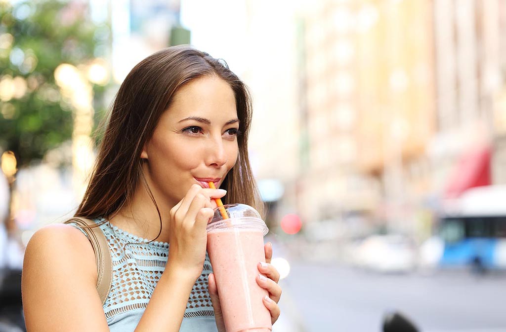 professional woman sipping a whey protein smoothie