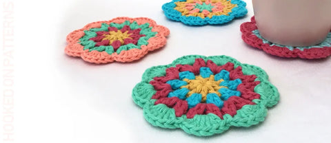 funky crochet coasters - multicoloured crochet coasters shown against a white background