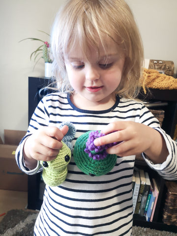 Play based learning with SBKM Spring Play Set. Ava holding a crocheted butterfly and lavender plant