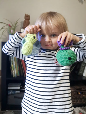 Young girl holding up crocheted butterfly and lavender plant