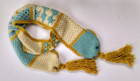 crochet scarf pattern for beginners - scarf crocheted in ivory, blue and gold yarn against a white background