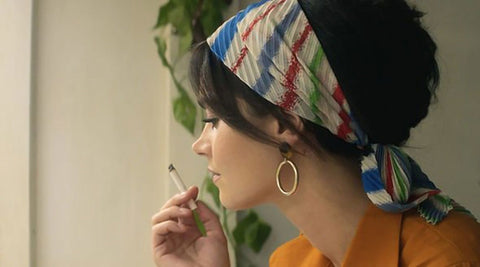 woman in stripe cloth headband holding cigarette