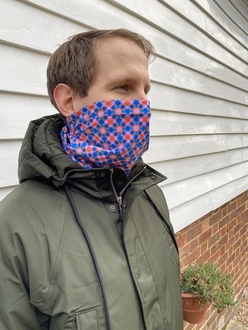 image of man in snood neck warmer designed with pink and blue geometric shapes