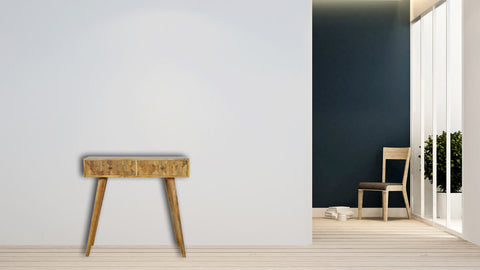 Une table console maquillage en bois massif de forme rectangulaire sculptée à la main pour une maison bourgeoise tendance et contemporaine.