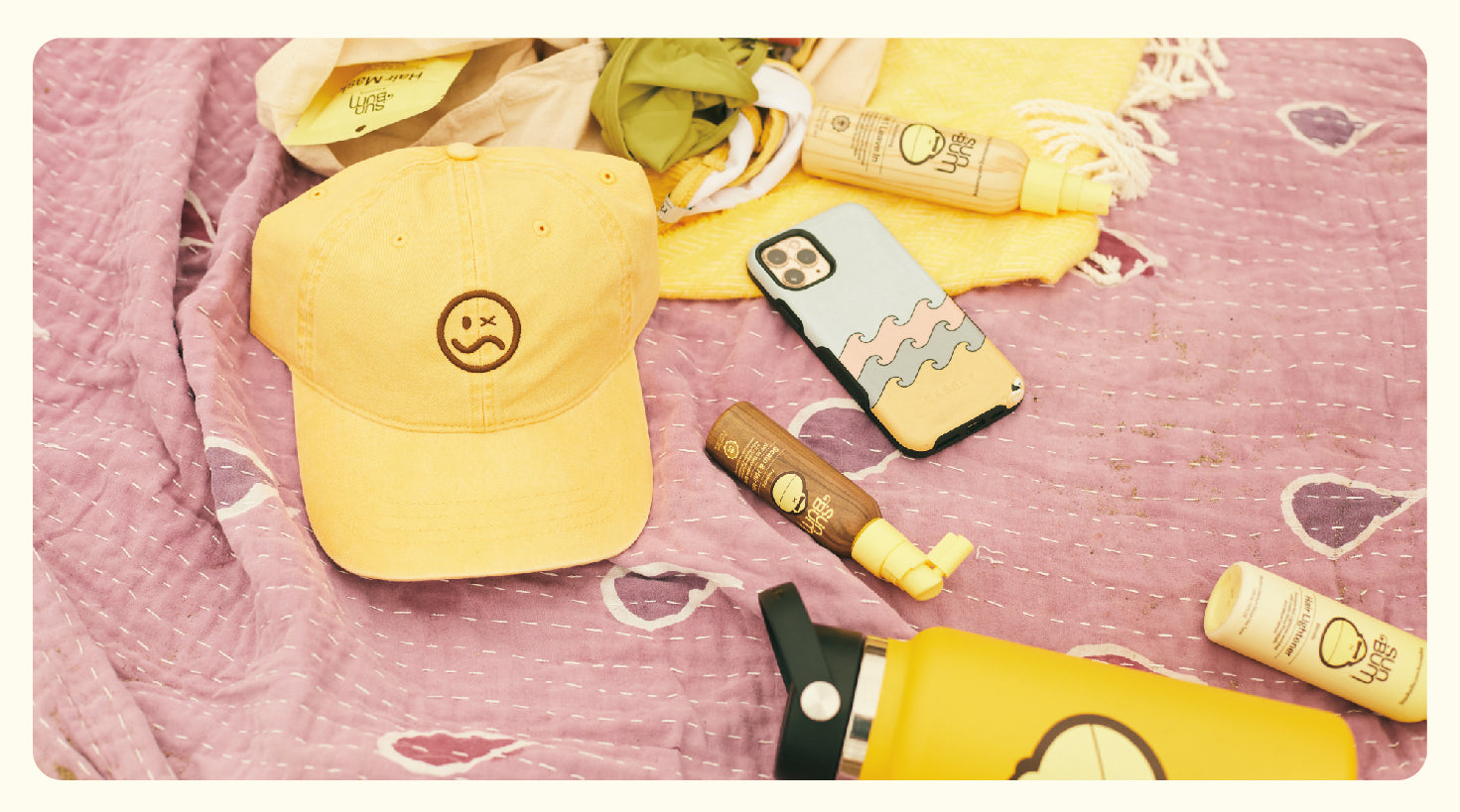 The Summer McKeen x Sun Bum Dad Hat on a towel with Sun Bum hair products