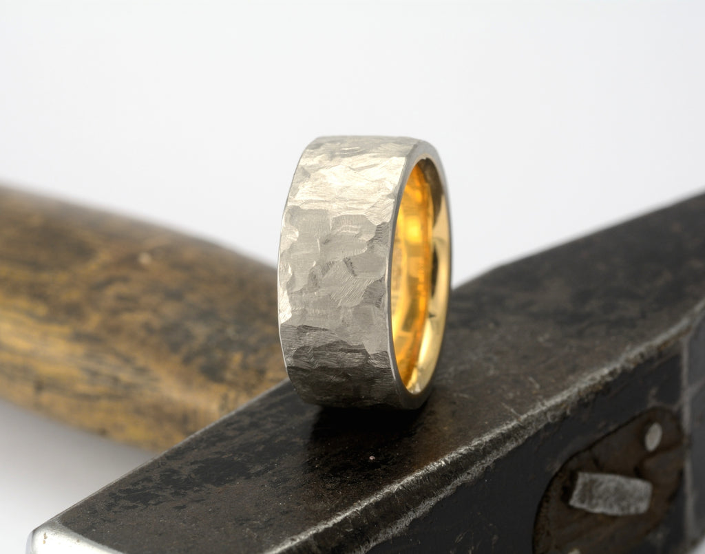 Hammered platinum wedding ring on top of hammer