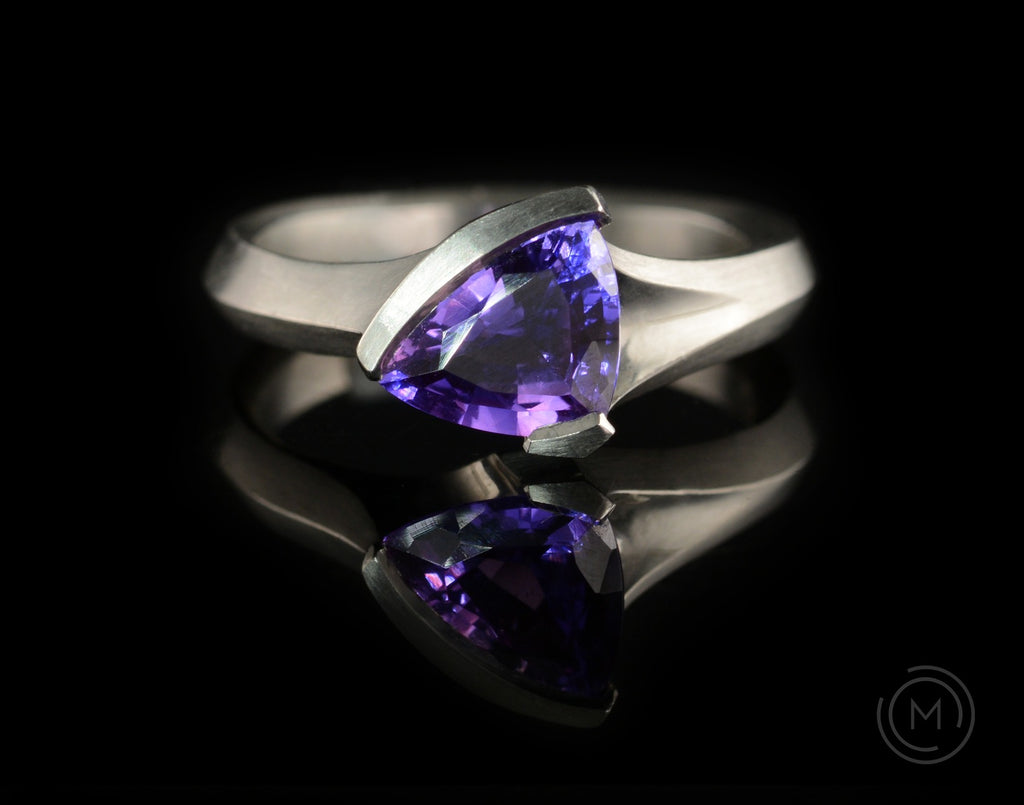 Carved platinum Arris ring with purple trillion sapphire