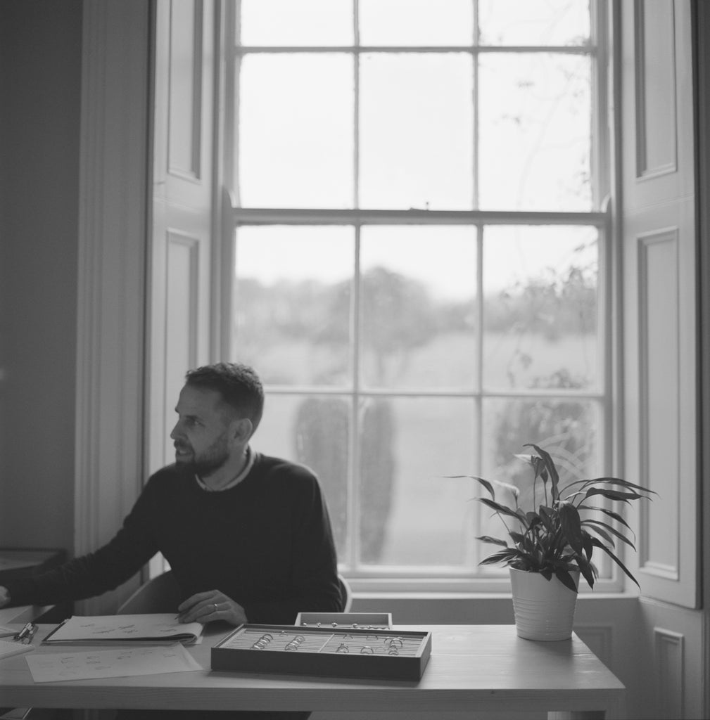 David McCaul sitting at desk in McCaul Dublin workshop