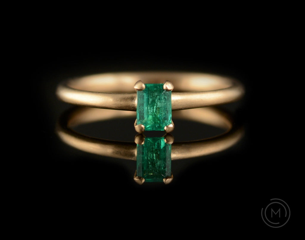 Bright green emerald and rose gold four claw engagement ring