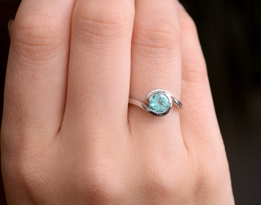 Bespoke platinum and paraiba tourmaline engagement ring on hand