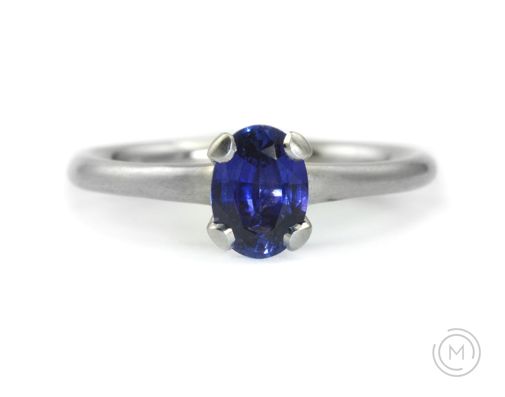 Oval sapphire and platinum four claw engagement ring