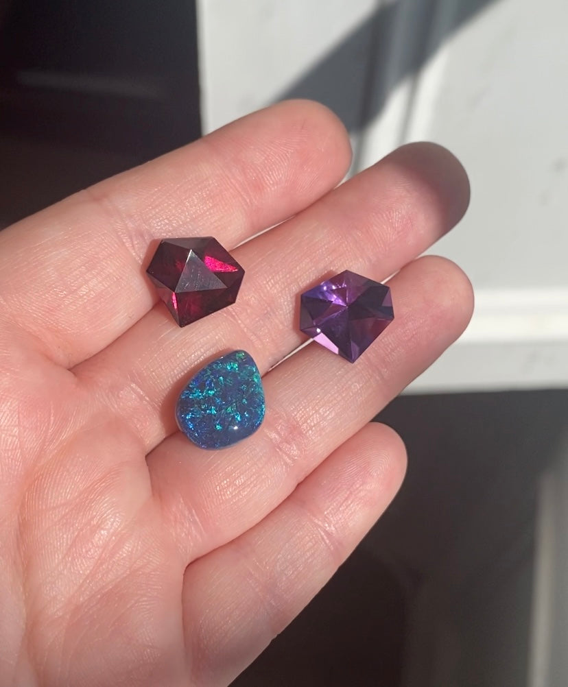 Garnet and amethyst and opal stones on hand in light