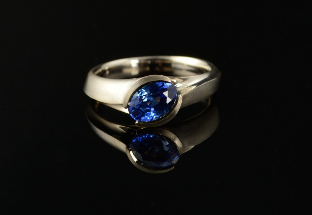 Carved white gold and blue coloured sapphire engagement ring