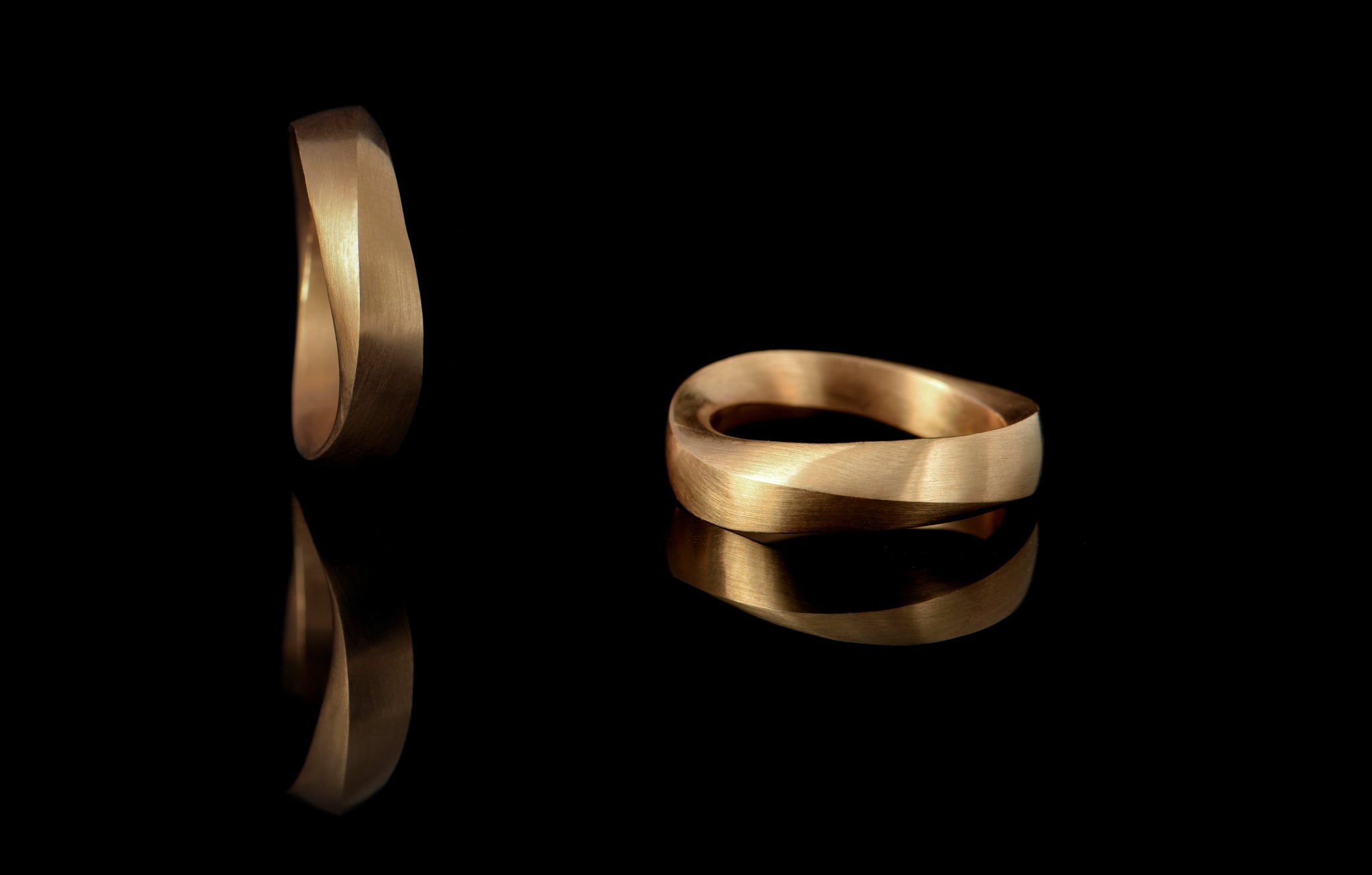 Two angles of curved wave mobius wedding band