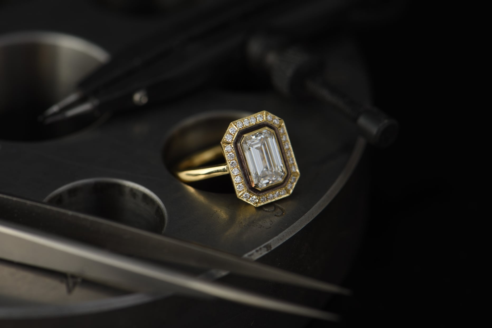 Yellow gold and white emerald cut diamond ring with halo of white diamonds, black rhodium border detail