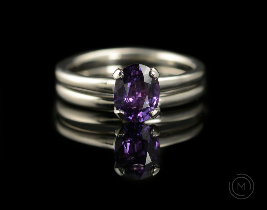 Four claw engagement ring with oval purple coloured sapphire gemstone