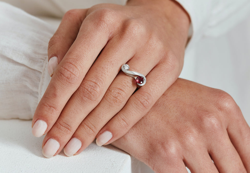 Ruby and white diamond zeta ring in platinum on hand