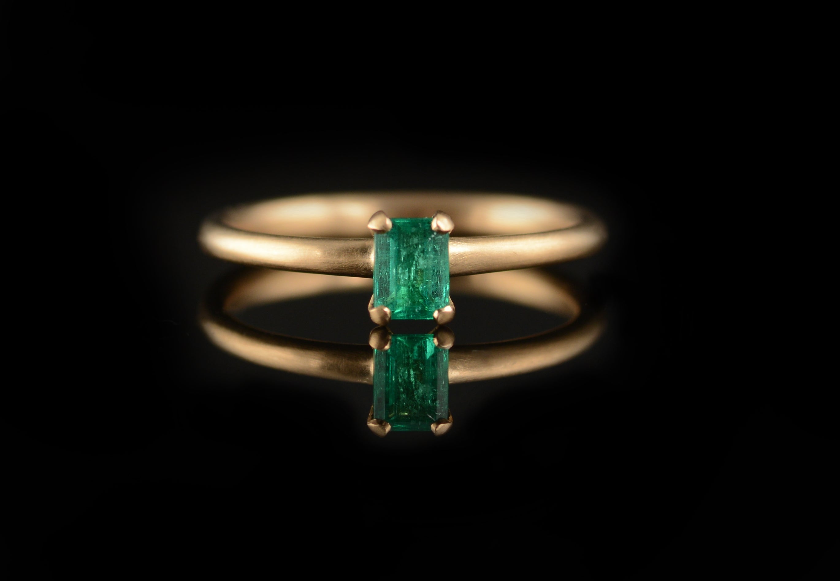 Rose gold and rectangular emerald claw engagement ring