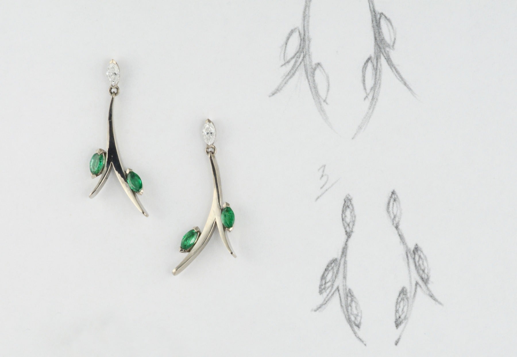 Forged white gold earrings set with marquise emeralds and diamonds