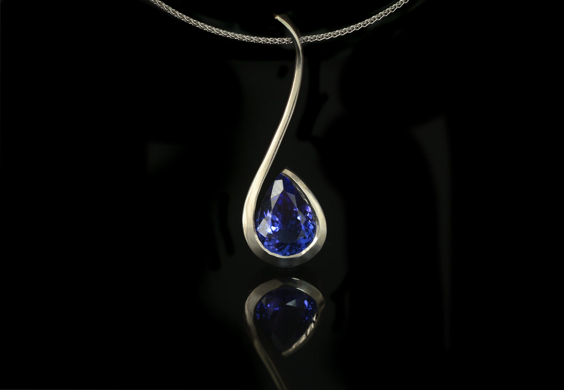 Forged white gold pendant with pear tanzanite
