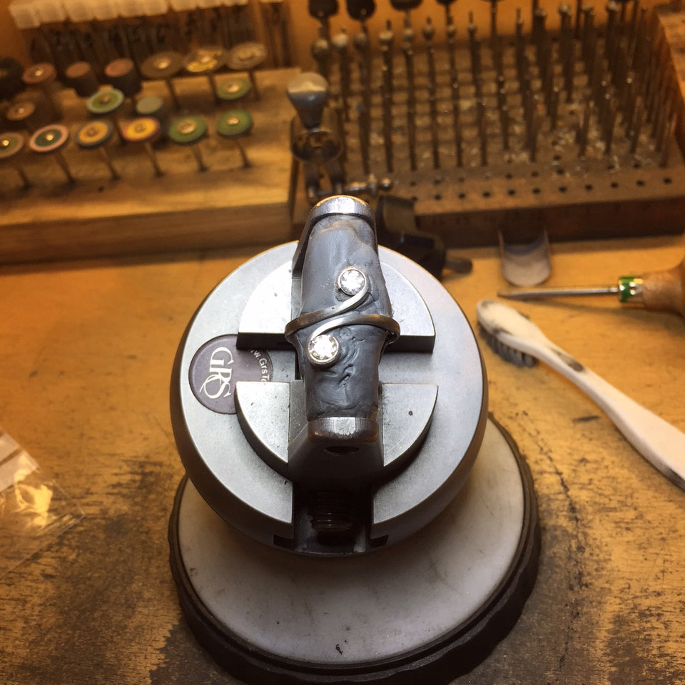 Forged platinum cocktail ring being set with two diamonds