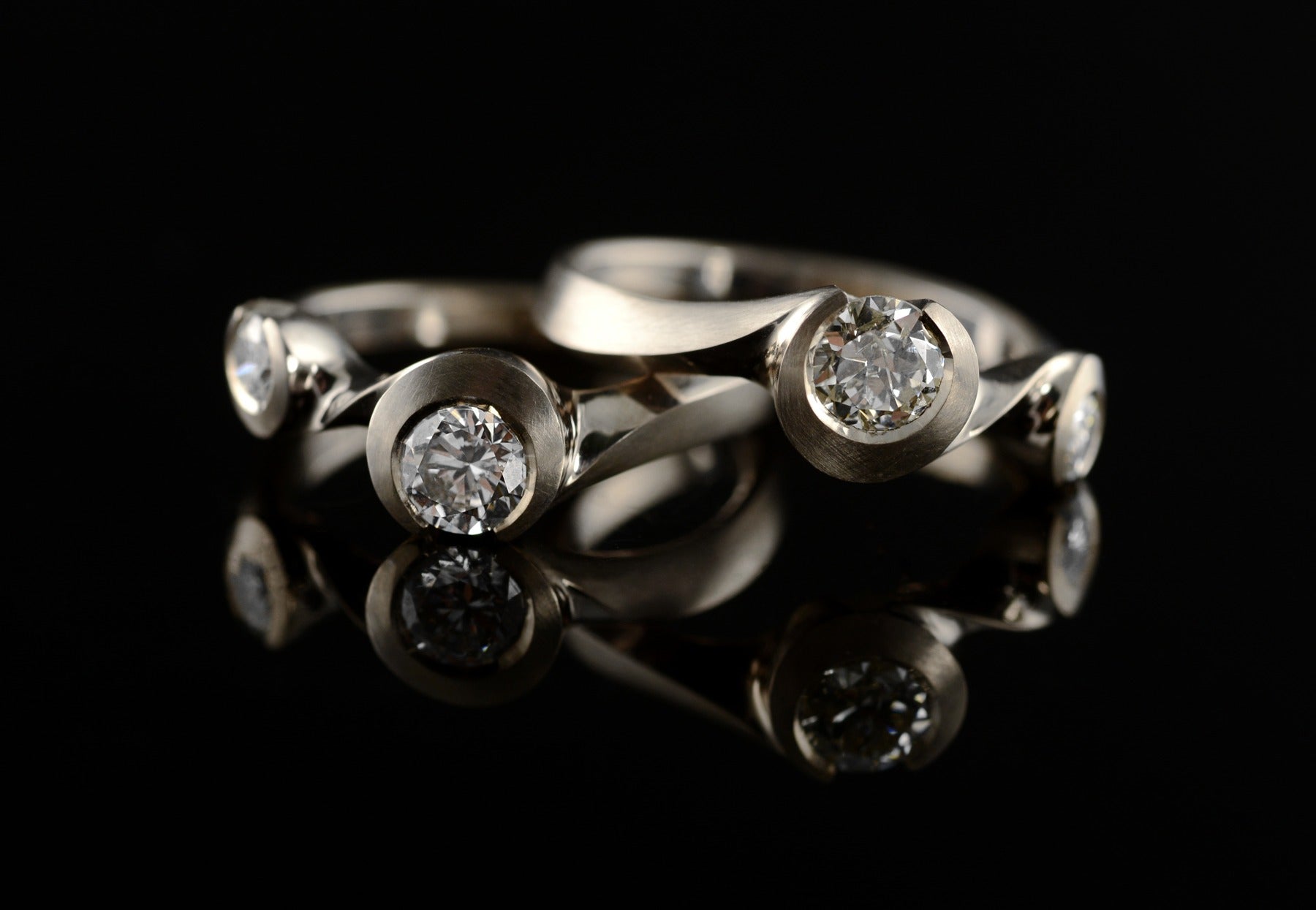 Arris carved white gold and diamond interlocking rings