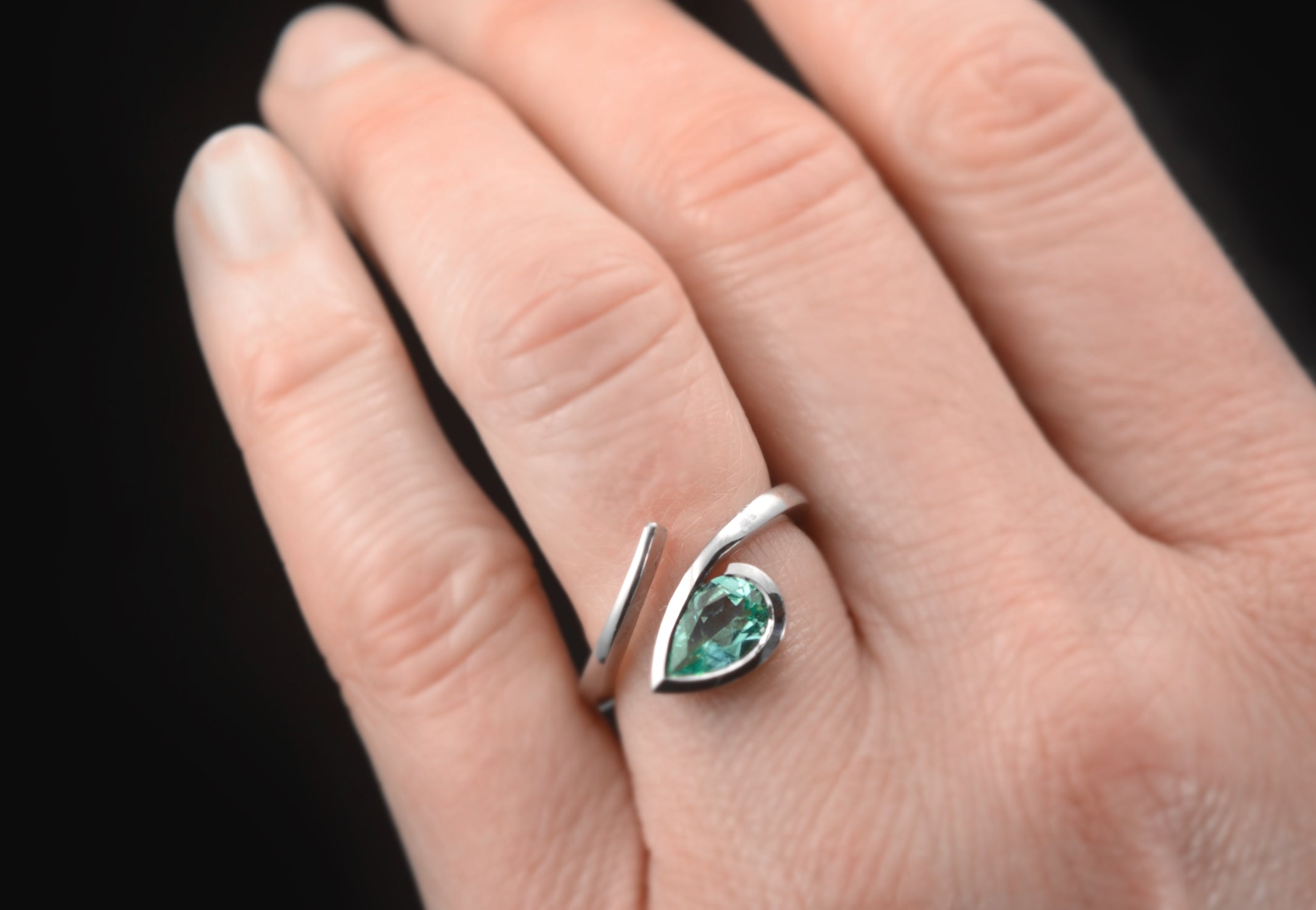 Paraiba tourmaline twist engagement ring on hand