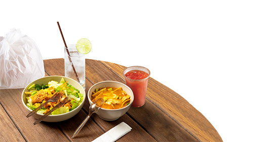 Image of a salad, soup, and drinks on a wooden table