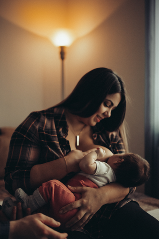 Woman sitting breastfeeding baby