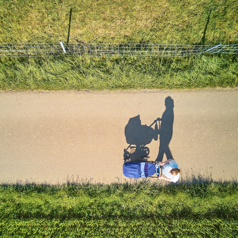 Image or parent pushing a pram in nature from Unsplash