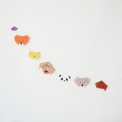 Origami animal hanging bunting featuring an orange bear, yellow cat, spotted dog, black and white panda, beige koala and brown dog, made for NiMi Projects origami workshop.