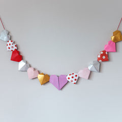 Bunting of 3D hearts in multicolors and patterns, made for NiMi Projects origami workshops.