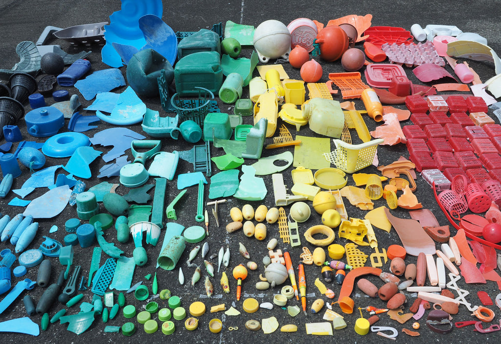 Recycled marine plastic, sorted into blue, green, yellow and red piles, laid out ready for processing into Buoy homeware products, made in Japan from waste collected on Japanese shores.