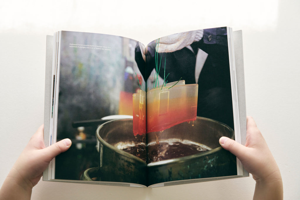 A photospread image of a keyboard piece being dyed a gradient orange by Toya Senryo in Tokyo, featured in sankaku Vol. 1, a book of interviews with craftspeople and other creators based in Tokyo.