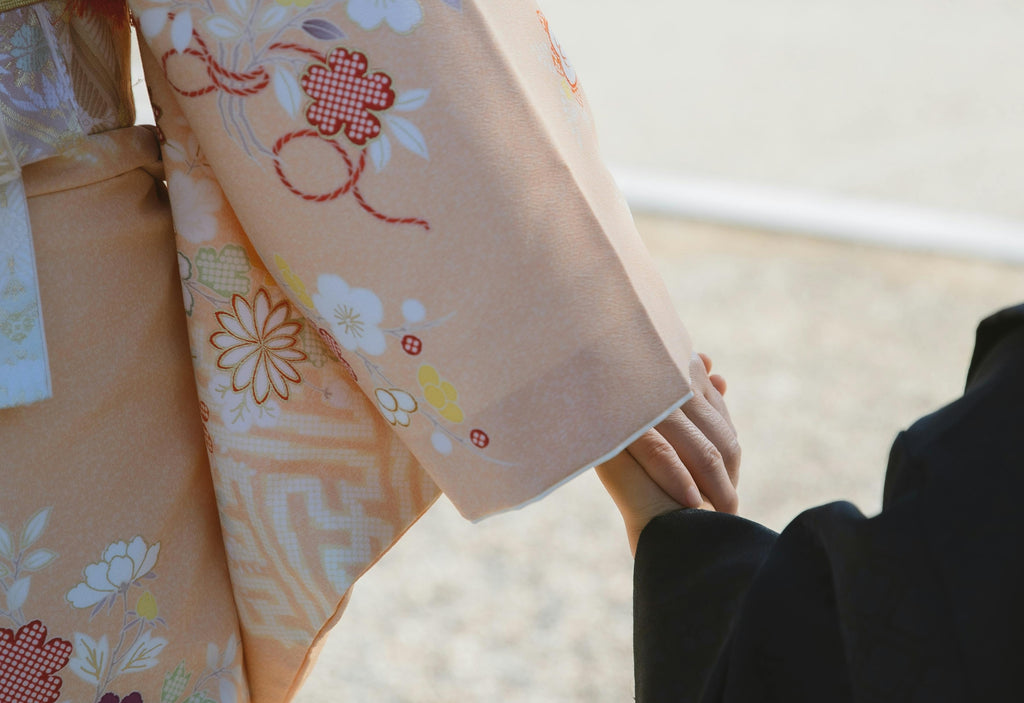 Woman in kimono holding hands with a child