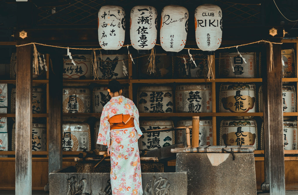 A woman looks at sake barrels at Fushimi Inari Taisha, Kyōto-shi, Japan.