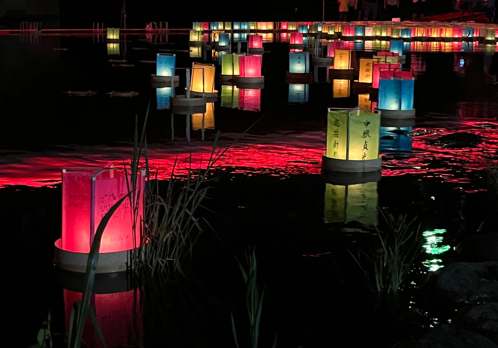 Paper lanterns float along a river toward the sea in Ito, Shizuoka, Japan. As part of the traditional Japanese Obon festival, each lantern is written on with the names of deceased loved ones to welcome their spirits back to earth for the holidays.