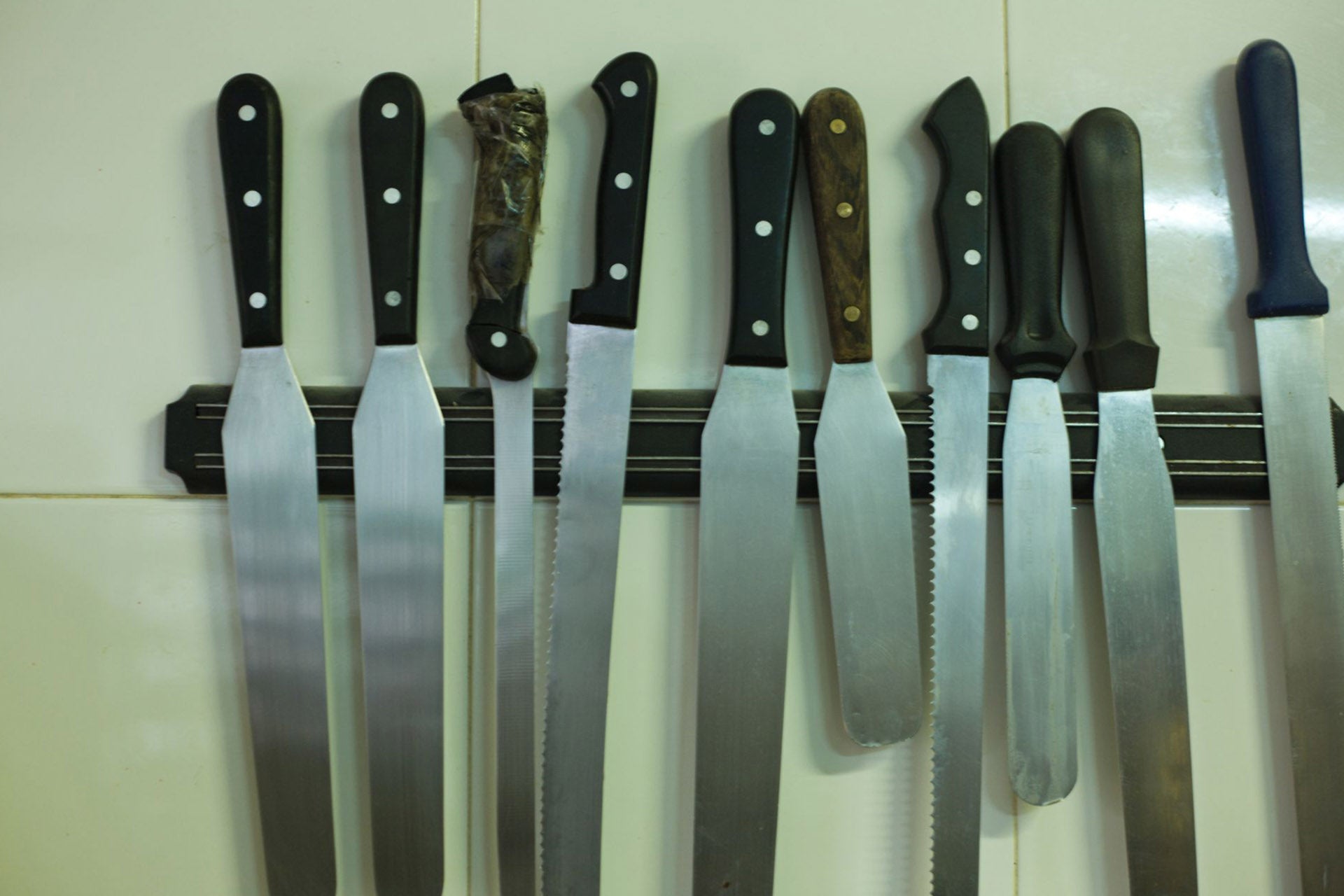 A set of knives stored on a magnetic knife rack