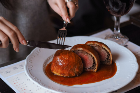 A person cutting beef wellington