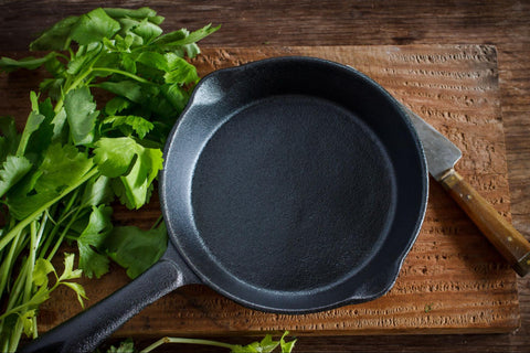 An empty cast iron pan on a chopping board