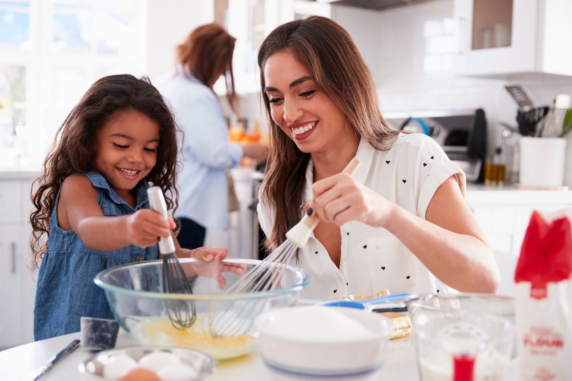 A grandmother, daughter, and granddaughter baking pastries in the kitchen