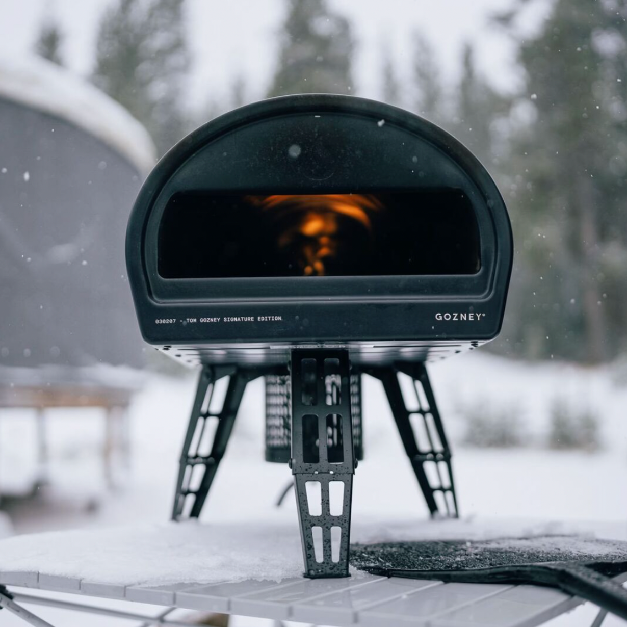 A Gozney Roccbox cooking a pizza outside