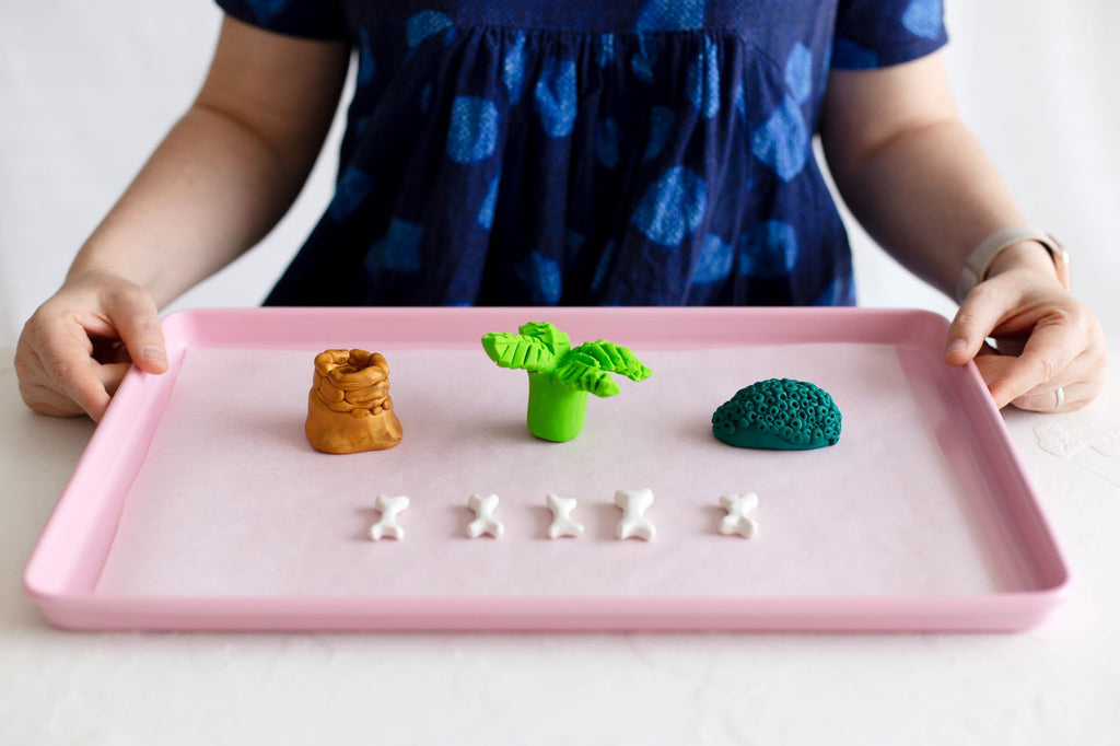 DIY baked clay dinosaur creative play fun with wooden dinosaurs in a baking tray