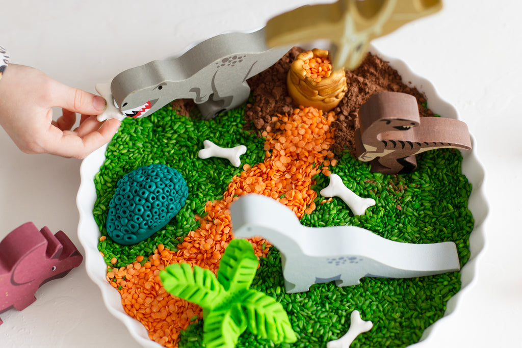 DIY Creative Play - Dinosaur FIMO fun with wooden dinosaur toys in a baking tray with coloured rice